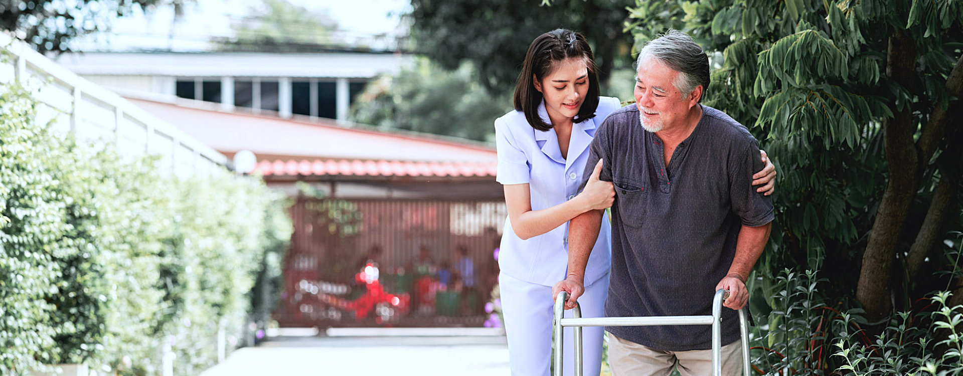 caregiver assisting senior man walking