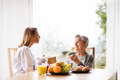 a nurse and senior woman sitting in the chair talking