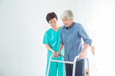 caregiver assisting senior woman walking