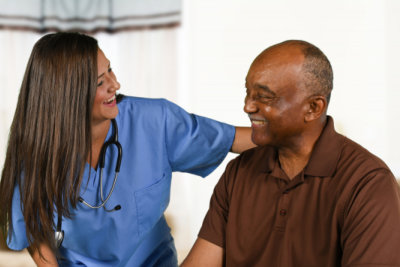 nurse and senior man smiling