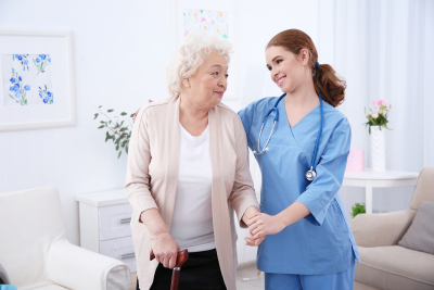nurse and senior woman smiling in light room