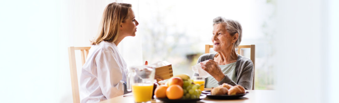 a nurse and senior woman sitting in the chair talking