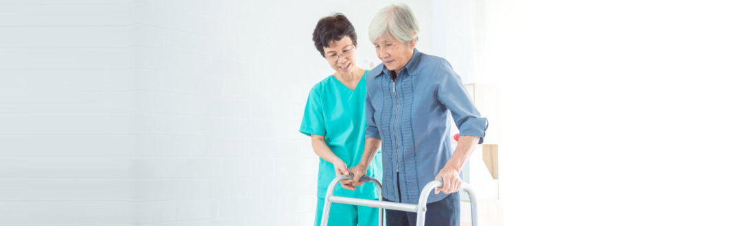 caregiver assisting senior woman walking